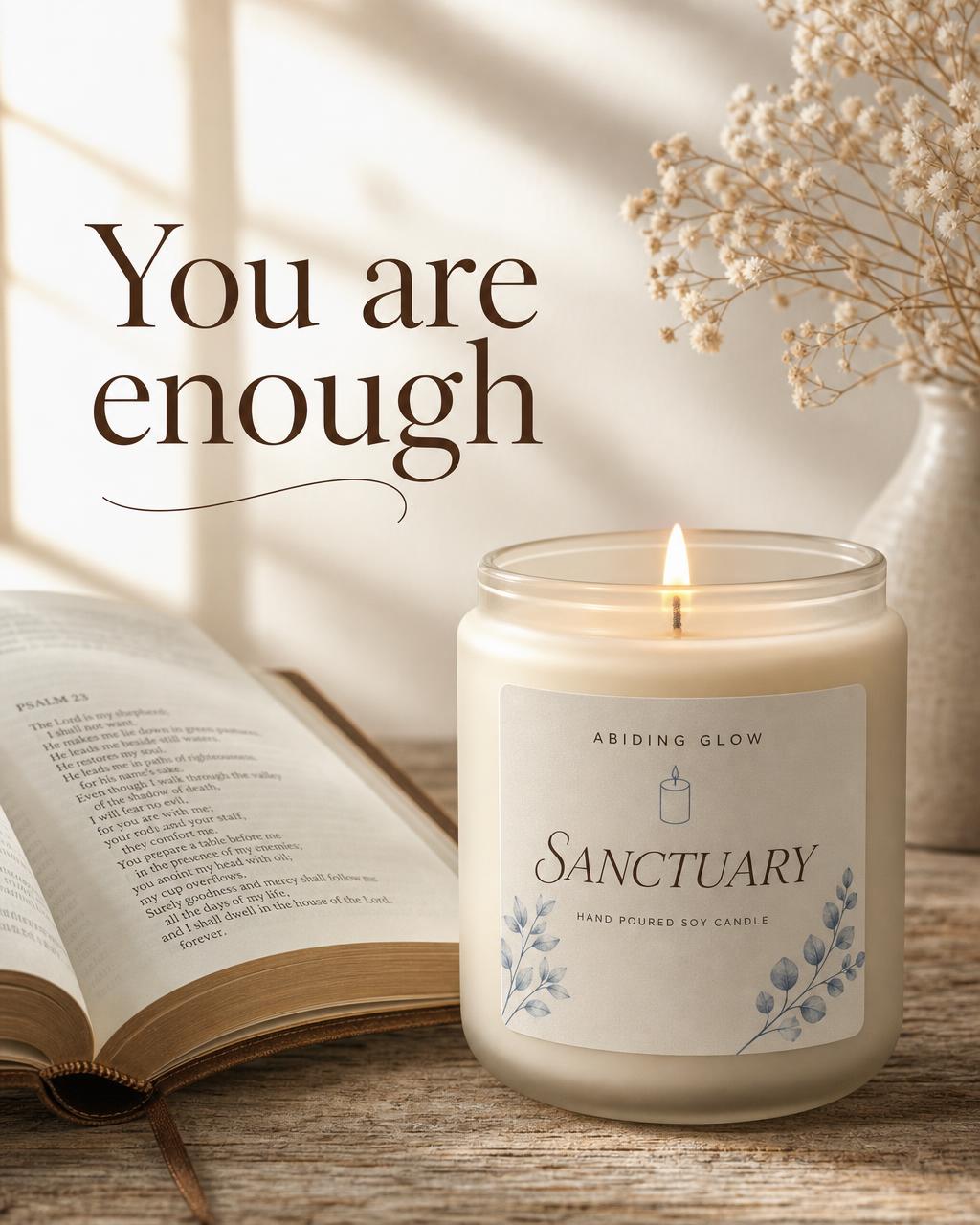 A lit Abiding Glow Sanctuary candle beside an open Bible with the message You are enough